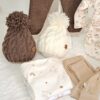 ajuar de nacimiento con tejidos a mano y prenditas de algodón